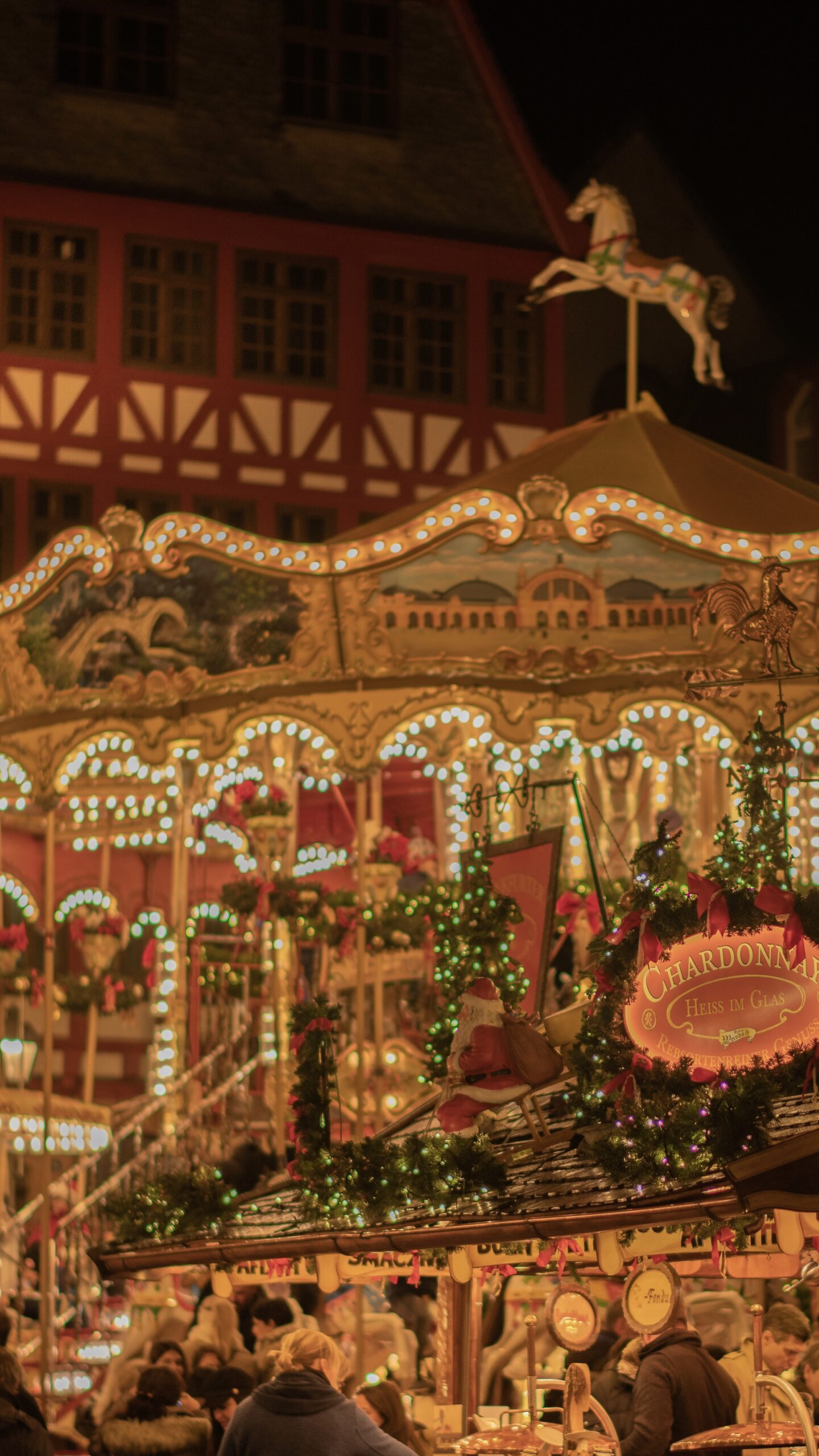 lit up carousel at night with christmas decorations at a christmas market in europe