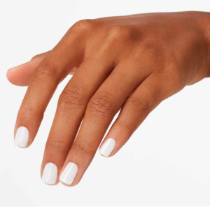 woman's hand with finger nails painted with white nail polish against a white background
