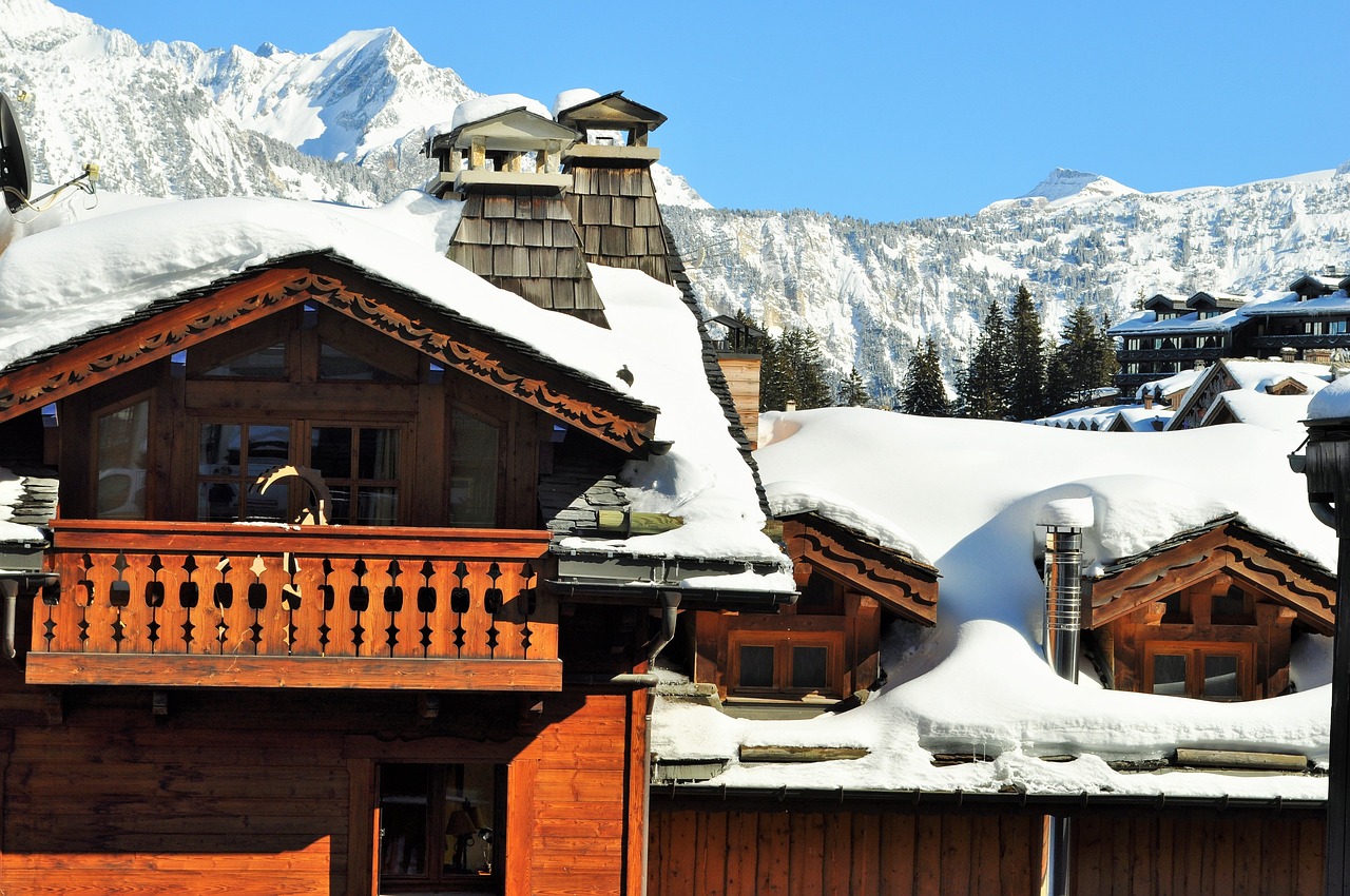 snow covered chalet with mountains and blue sky in background