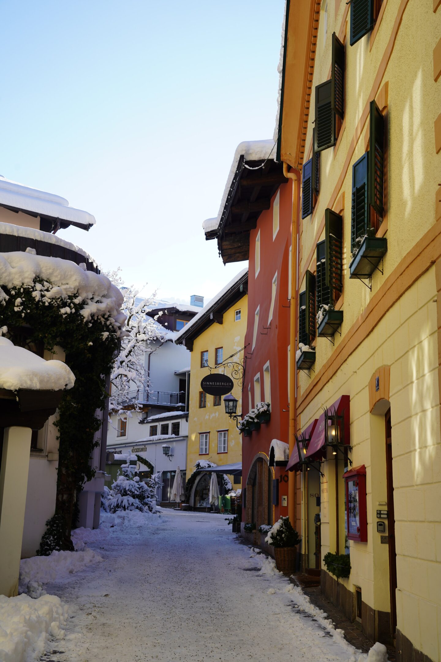 europe colored buildings with snow covered street and roofs and blue sky background