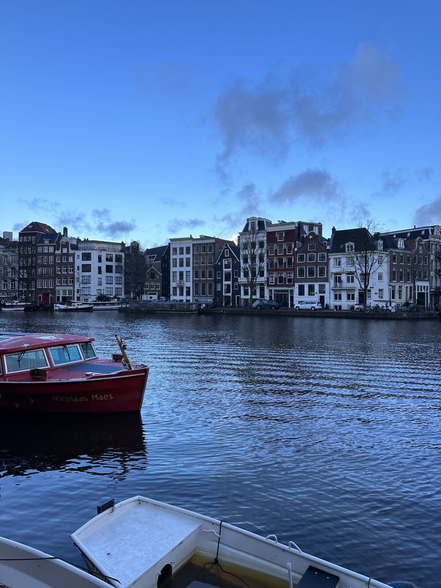 blue hour morning in amsterdam on the canal with Canal houses in background 