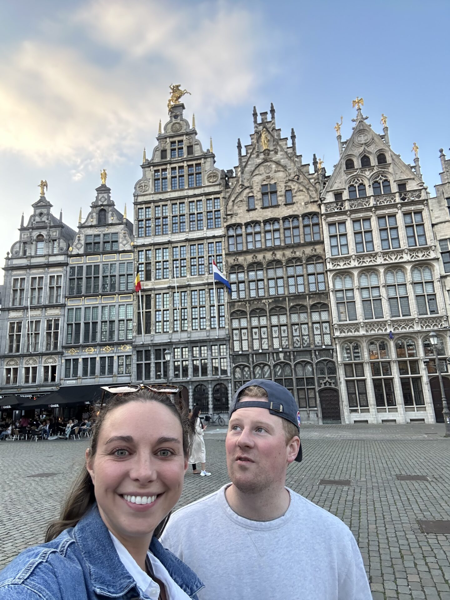 woman and man taking a selfie in Antwerp belgium city center with belgium buildings and architecture in background